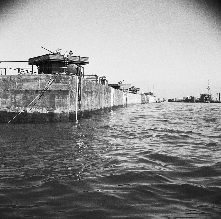 A line of Phoenix caisson units part of the Mulberry artificial harbour at Arromanches 12 June 1944 Harrison